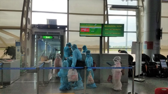 Hành khách mang khẩu trang, đồ bảo hộ y tế đầy đủ trước khi lên máy bay.